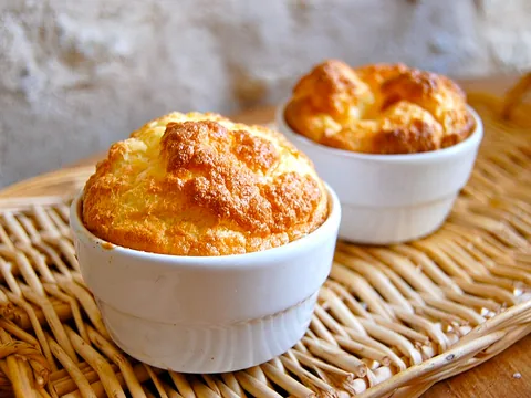 Golden baked soufflés in white ramekins