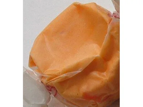Orange salt-water taffy visible through clear cellophane