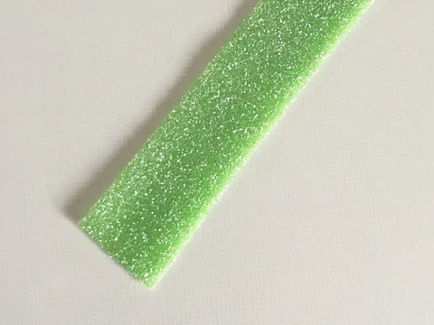 A green sugar-coated Haribo sour candy ribbon
