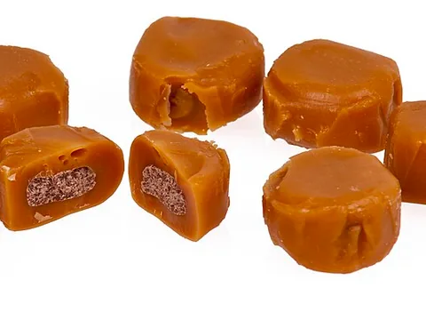 Unwrapped filled caramel candies, including one cut piece