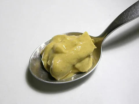 Smooth Dijon mustard on a spoon