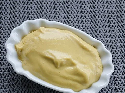 Prepared yellow mustard in a white bowl