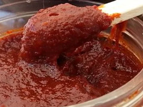 Thick fermented gochujang chilli paste on a spoon