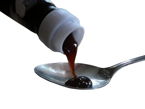 Dark oyster sauce poured onto a spoon