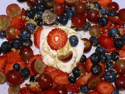 Sour cream served with berries and brown sugar