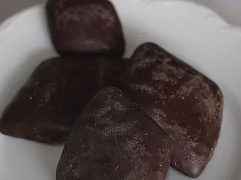 Chocolate-coated Neapolitan mostaccioli biscuits on a plate
