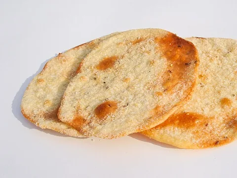 Two thin golden Andalusian olive-oil tortas on a white surface