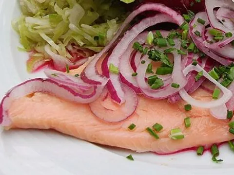 Smoked trout fillet topped with red onion and chives