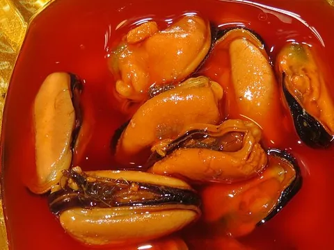 Mussel meats in escabeche sauce in a red bowl