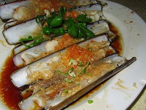 Steamed razor clam meats in shells with garlic and herbs