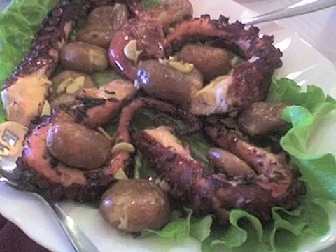 Portuguese roasted octopus with potatoes on a plate