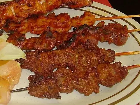 Grilled suya skewers and onions on a neat plate