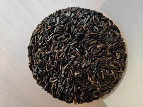 Black niger seeds on a white surface