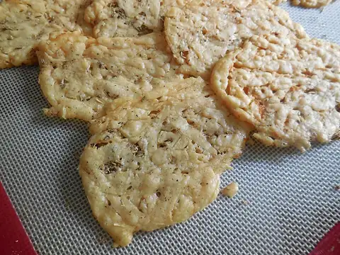 Flat baked cheese crisps on a baking mat